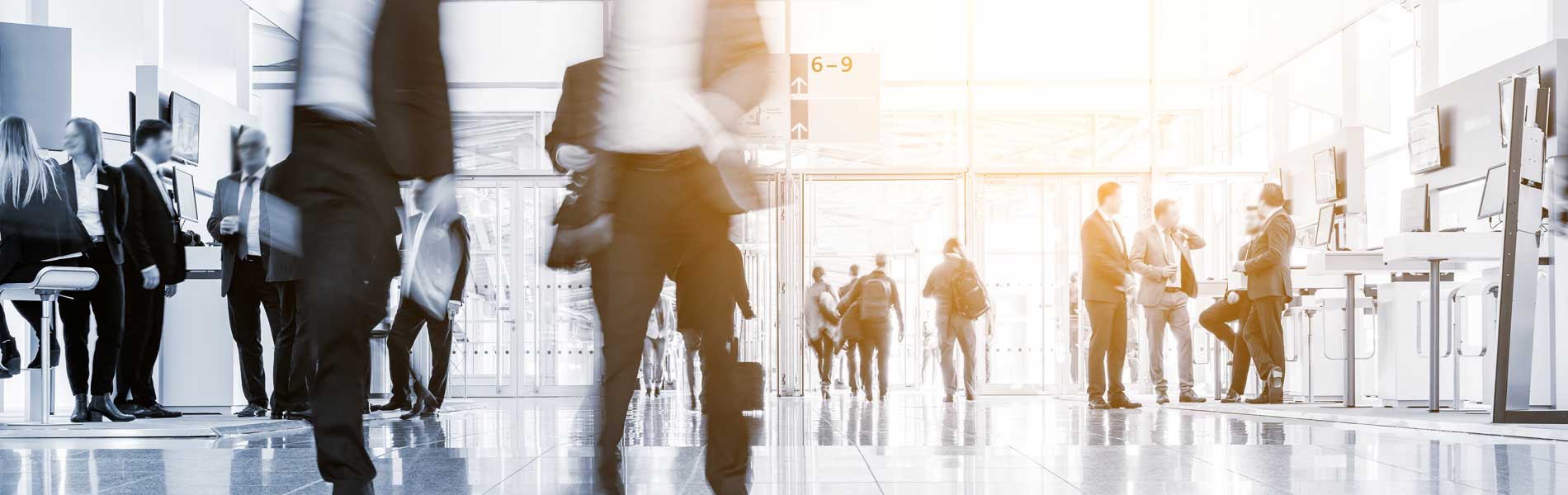 A busy office foyer - some people walking and others talking and standing